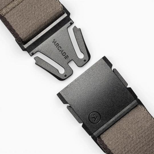 Close-up of the Arcade Belts Blackwood belt, featuring a gray fabric strap and a black metal A2 buckle engraved with "ARCADE," shown open on a light background.