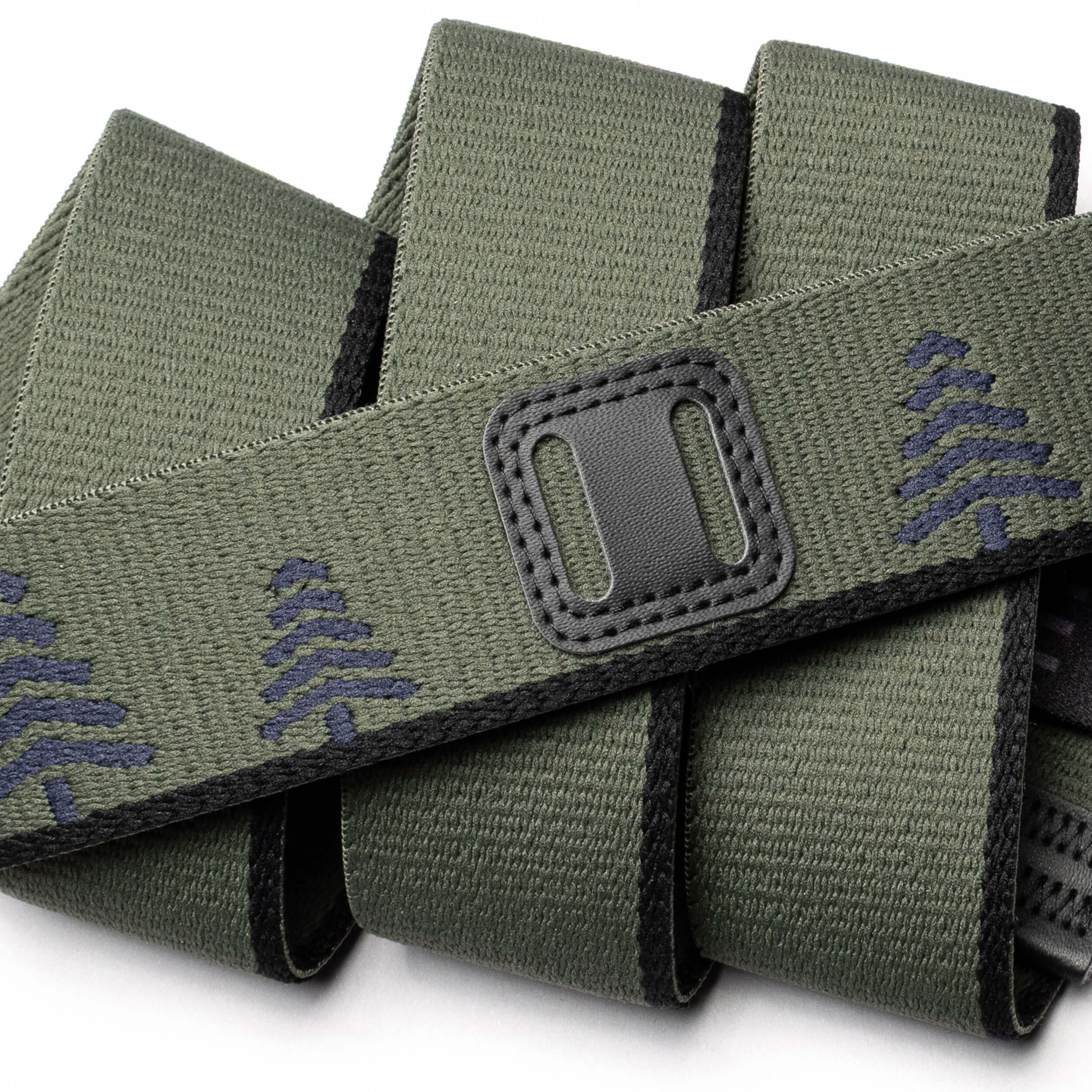 A close-up of the Arcade Belts Blackwood: a green fabric belt with black edges, a stitched rectangular A2 buckle, and a repeating dark green tree pattern—ideal for outdoor explorers.