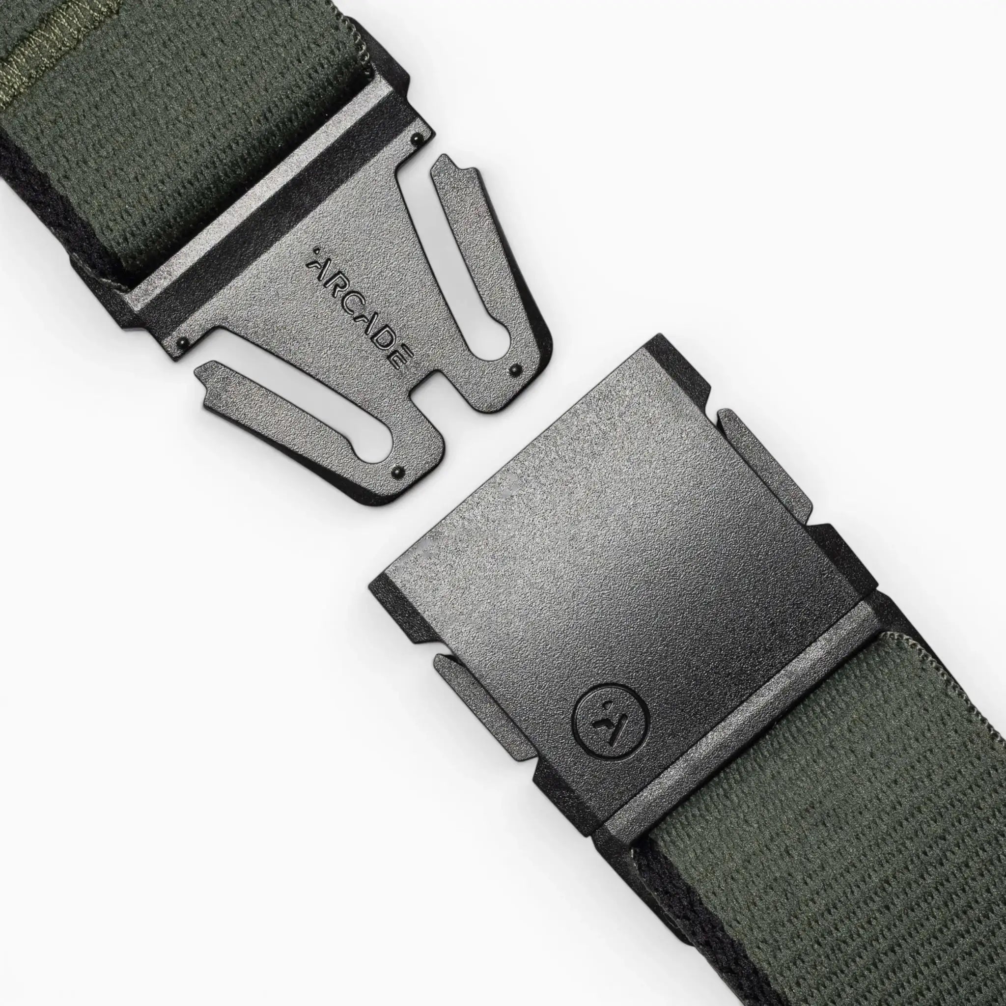 A close-up of a green Arcade Belts Blackwood fabric belt with a black metal A2 buckle, partially unclasped to reveal ARCADE engraved on the clasp.