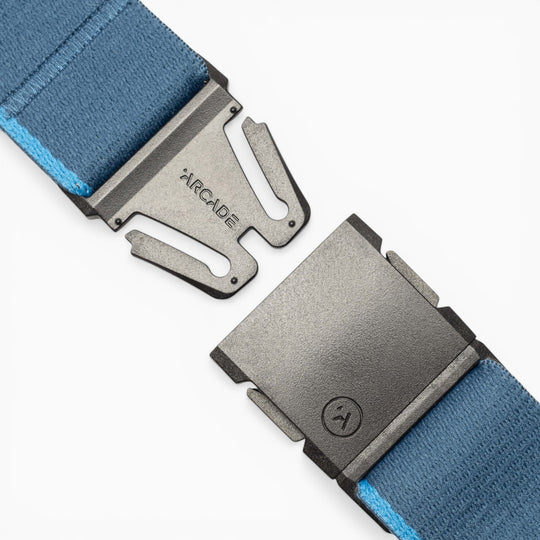 Close-up of the Arcade Belts Blackwood, a blue fabric belt featuring a metallic black A2 buckle. The buckle displays “ARCADE” engraved on one side and a small logo on the other, highlighting the signature Blackwood design. The fabric includes a light blue edge and is shown partially unclasped.