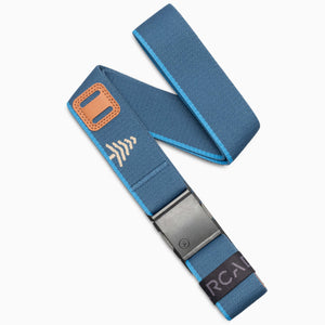 A Royal Sand elastic belt from Arcade Belts, featuring a metal A2 buckle, orange accent, and white arrow design. The end showcases a black label with partially visible “RCAN” text, reminiscent of an arcade classic. The Blackwood belt is displayed on a white background.
