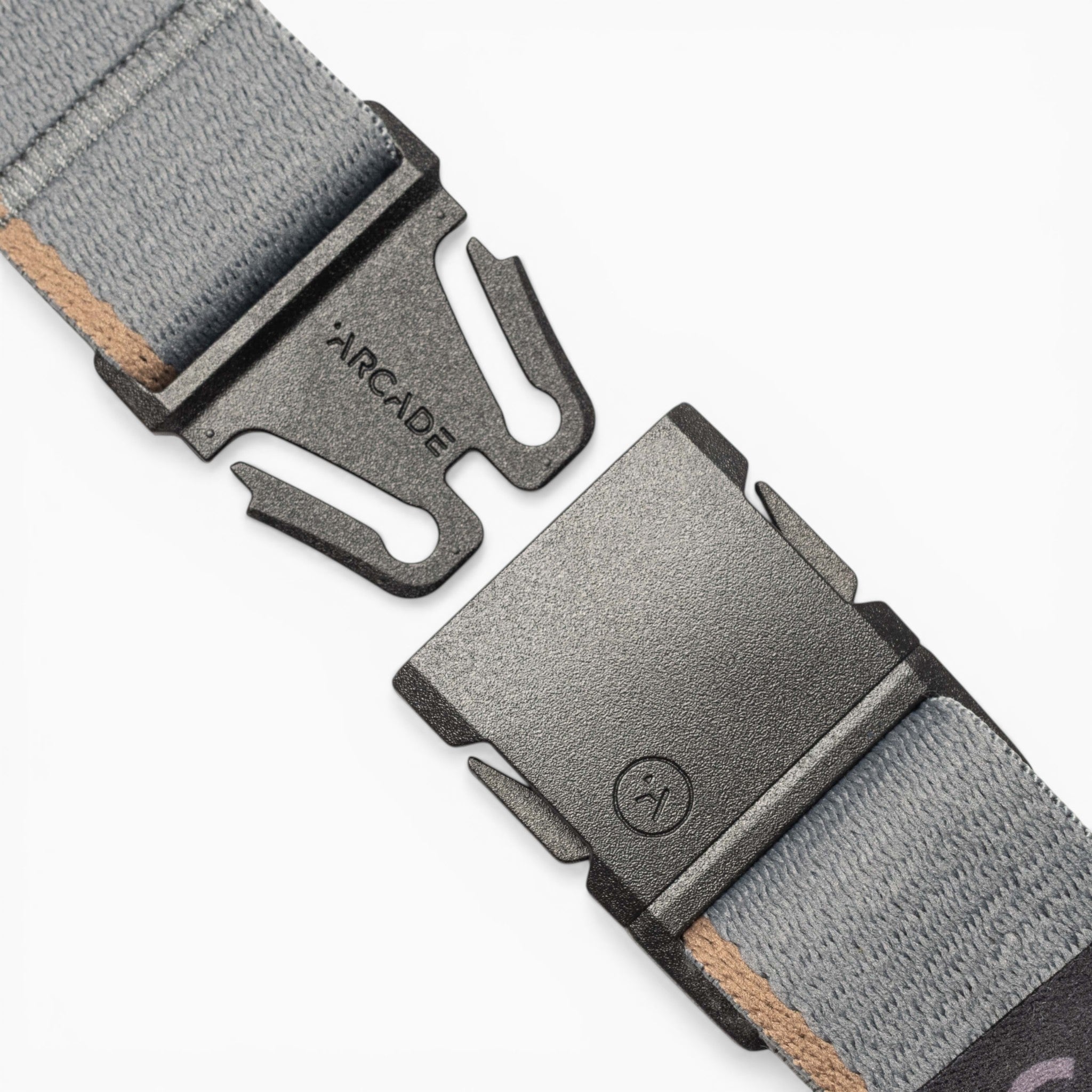 Close-up of a gray fabric Arcade Belts Blackwood belt featuring an A2 buckle, shown unclasped on a white background.