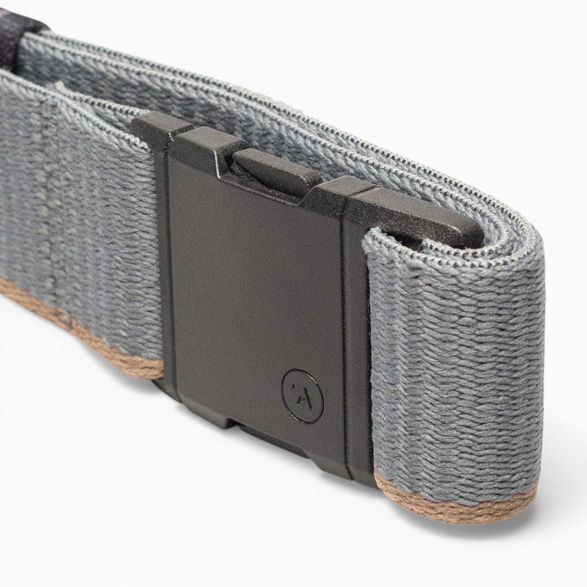 A close-up of a gray fabric strap with a black plastic buckle, featuring the signature A2 buckle from Arcade Belts. The strap, named Blackwood, displays brown edge stitching, while the buckle is adorned with a small circular logo for an iconic Arcade touch.