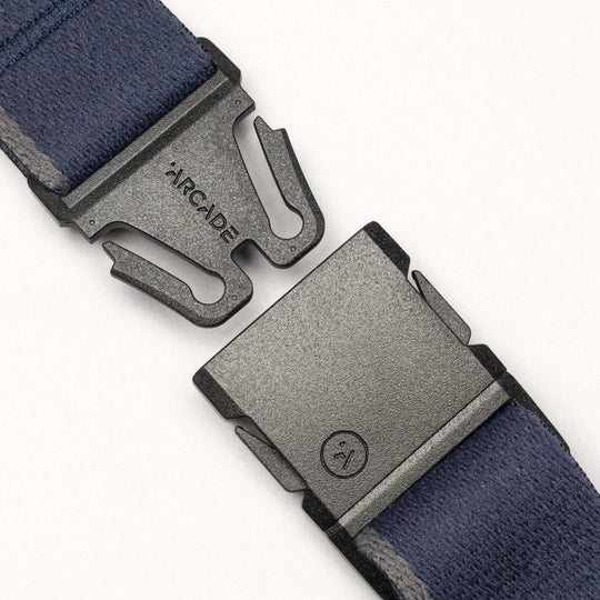 A close-up of the Arcade Belts Blackwood belt featuring a blue strap and a black A2 buckle. The partially open buckle reveals the Arcade Belts logo, all set against a plain white background.