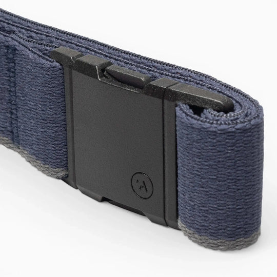 A close-up of the Blackwood belt by Arcade Belts, featuring a sleek dark blue strap and a black A2 rectangular buckle with a small circular logo, resting on a light gray surface.