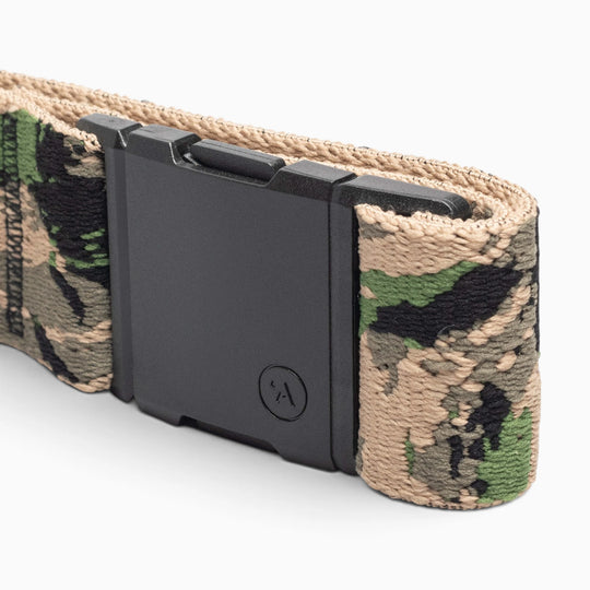 Close-up of a camouflage fabric belt with a rectangular black buckle. Part of the Island Collection by Arcade Belts, this Hawaiian-inspired accessory features a camouflage pattern in shades of green, tan, and black, capturing the adventurous Aloha spirit.