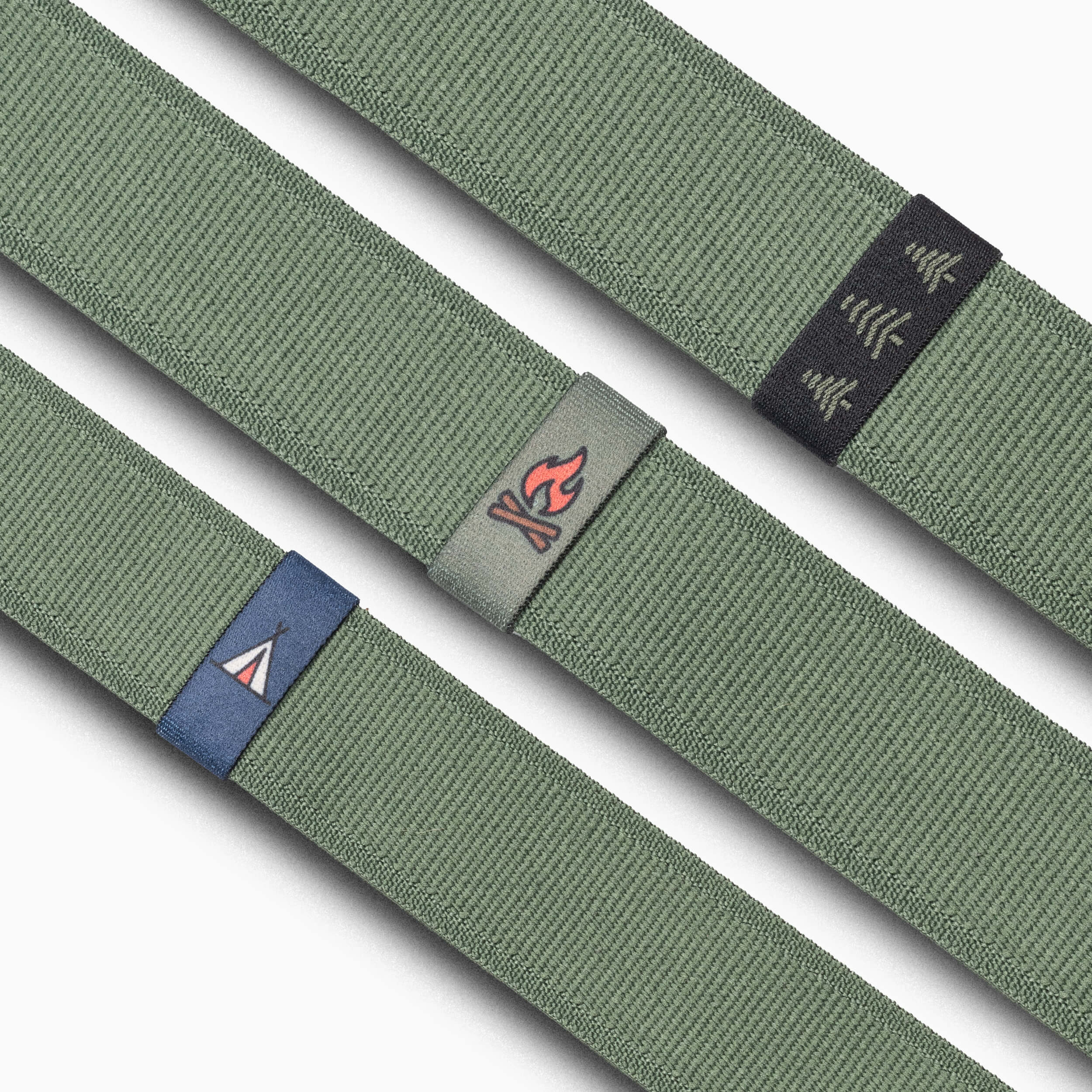 Three olive green Belt Loopkeepers by Arcade Belts, each Standard Width Adventure style, have colored tabs: white tent on blue, red campfire on gray, and three white trees on black.