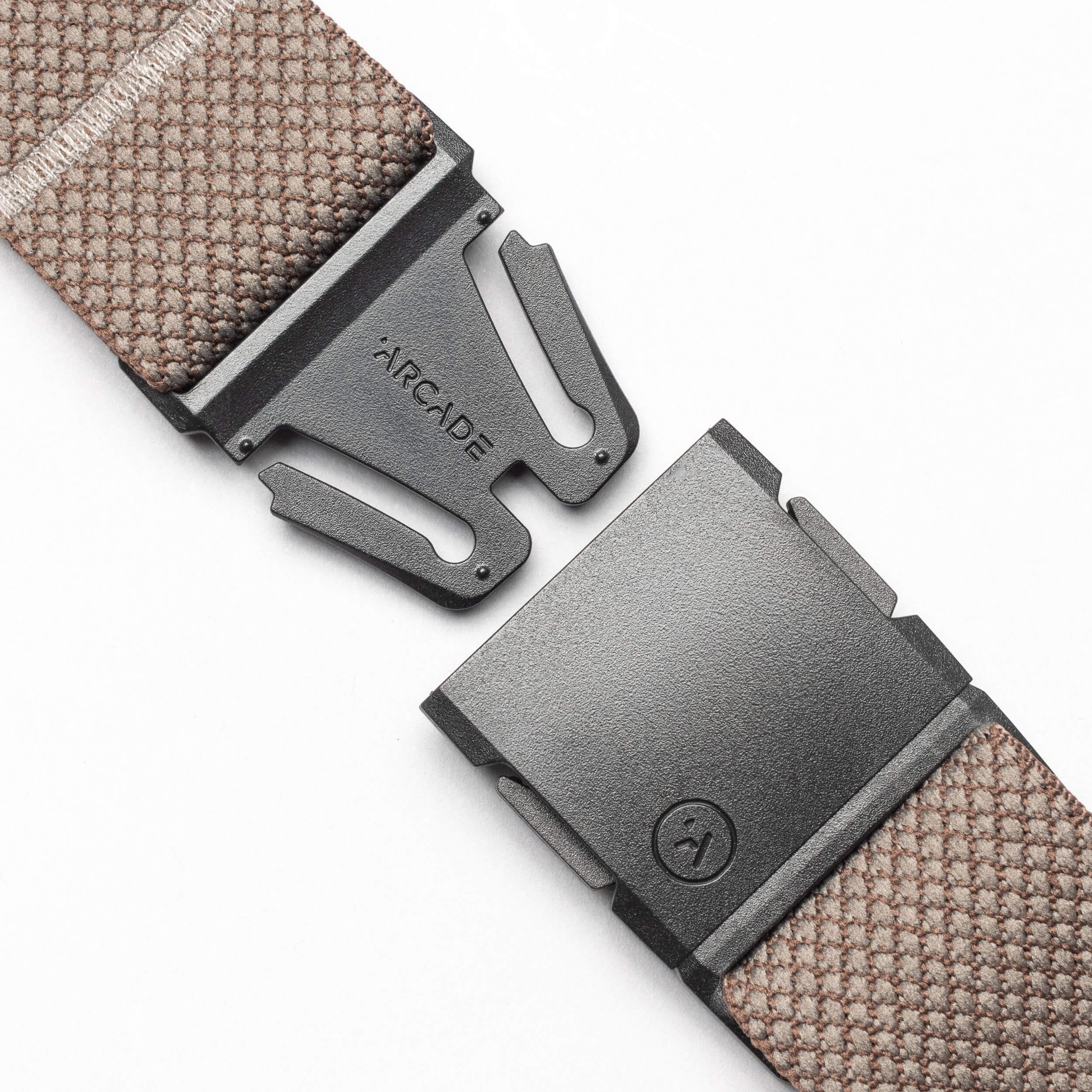 A close-up of the Arcade Belts Carry, a brown performance stretch webbing belt with a black metal A2 buckle engraved with the Arcade logo, shown partially unclasped against a plain white background.