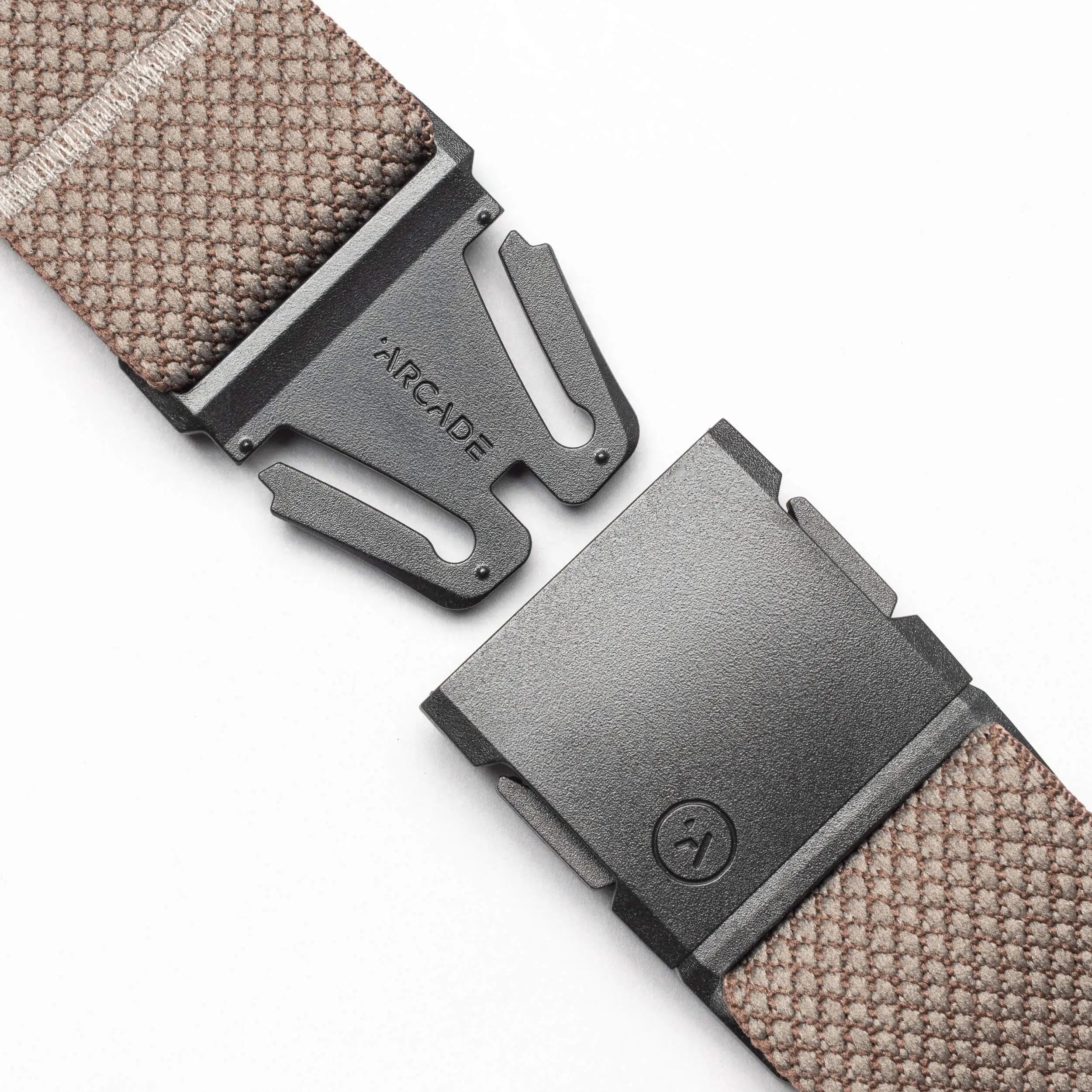 A close-up of the Arcade Belts Carry, a brown performance stretch webbing belt with a black metal A2 buckle engraved with the Arcade logo, shown partially unclasped against a plain white background.