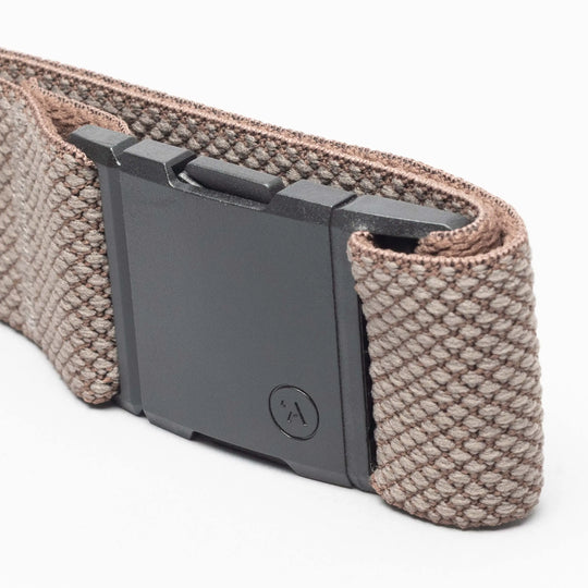 A close-up of the Arcade Belts Carry, featuring a woven brown fabric band with a unique weave and a rectangular black plastic clasp, displayed against a white background.