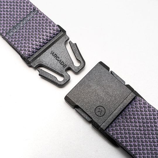 A close-up of the Carry belt by Arcade Belts, featuring an A2 buckle on a purple and white unique weave strap, shown unfastened against a light gray background.