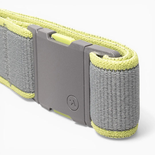 A close-up of a gray and yellow Arcade Belts Carto performance stretch belt strap with a rectangular plastic buckle, featuring a small circular logo—perfect for adventure.
