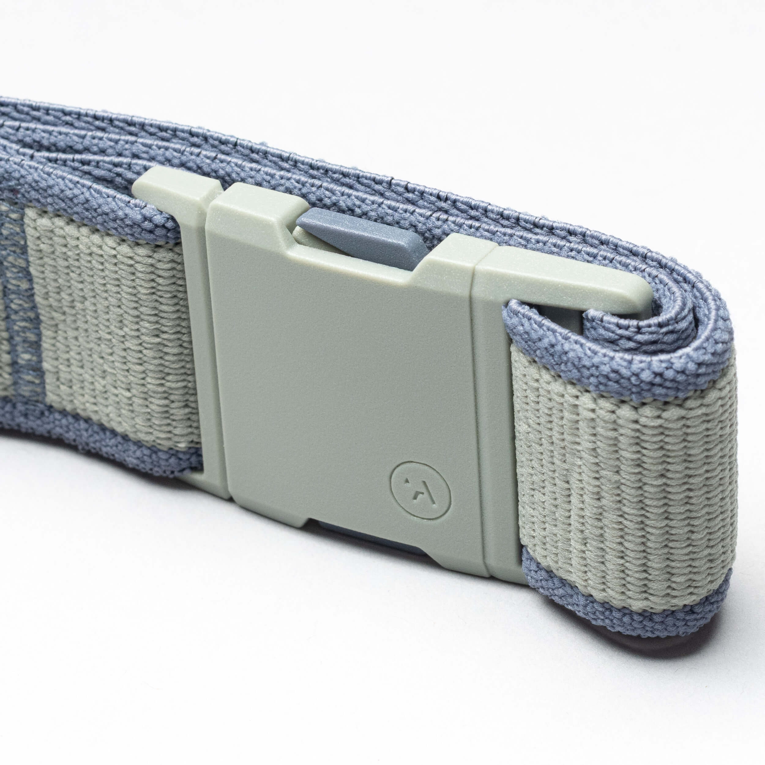 A close-up of a light gray plastic buckle on a folded blue woven strap highlights the durability of the Carto performance stretch belt by Arcade Belts, shown against a plain white background—ideal for any adventure.