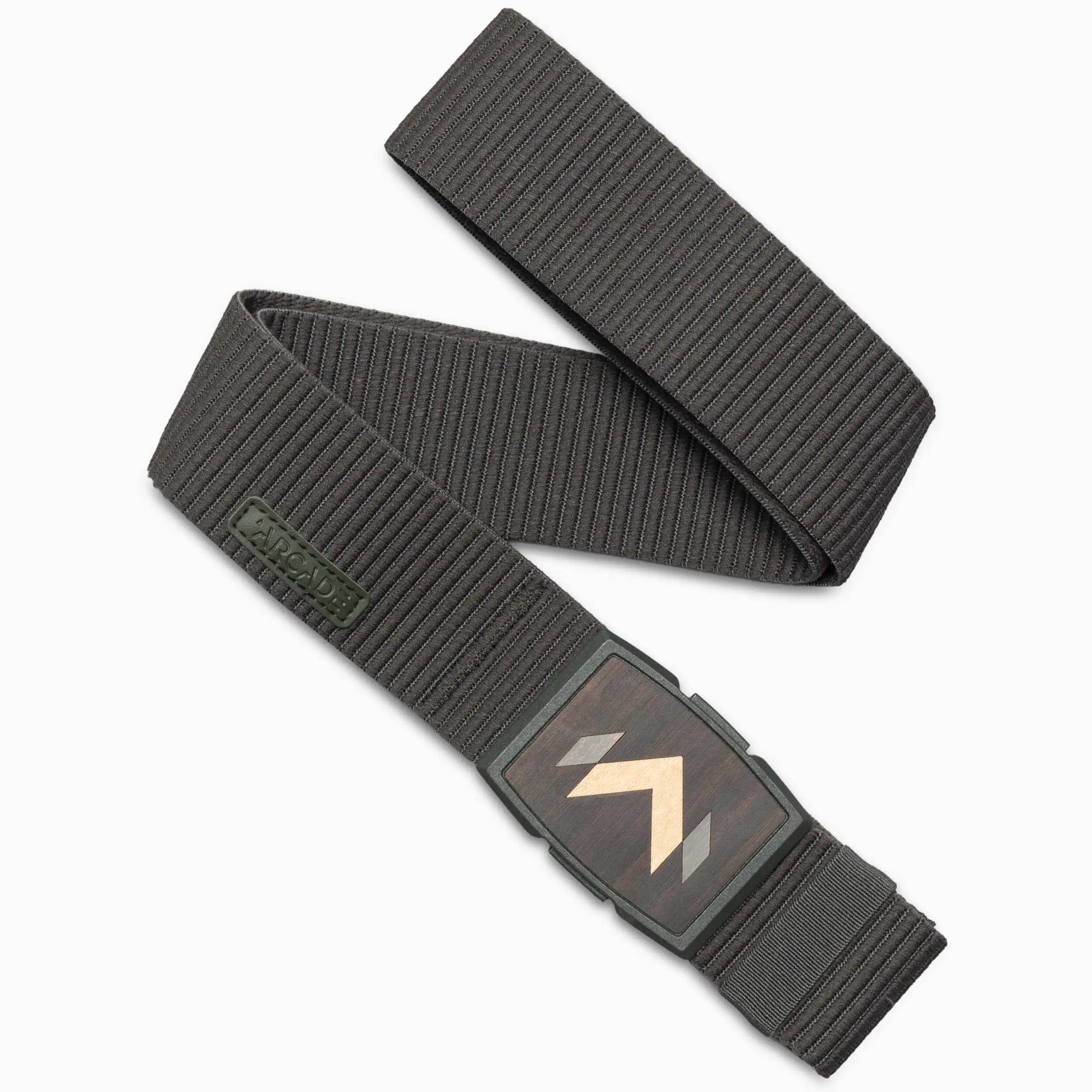 The Arcade Belts Carver in Army is a textured stretch belt with a rectangular, wood-inspired buckle featuring two chevron patterns in contrasting shades. It’s shown in a loose S-shape.
