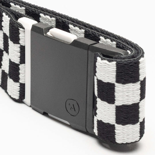 A close-up of the Arcade Belts Check, a black and white checkered fabric belt with a rectangular black plastic buckle, designed for comfort and style, shown against a white background.