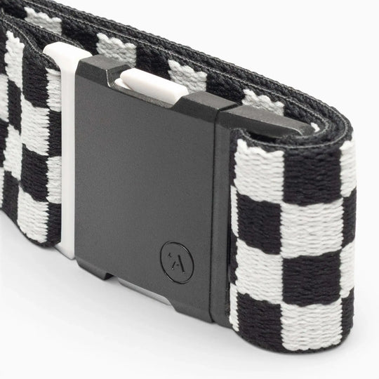 A close-up of the Arcade Belts Check, a black and white checkered fabric belt with a rectangular black plastic buckle, designed for comfort and style, shown against a white background.