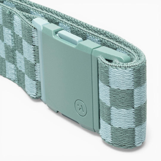 A close-up of the Check belt by Arcade Belts, featuring a checkered pattern in mint green and light blue with a matching mint green plastic buckle, crafted with performance stretch for comfortable wear that turns heads wherever you go.
