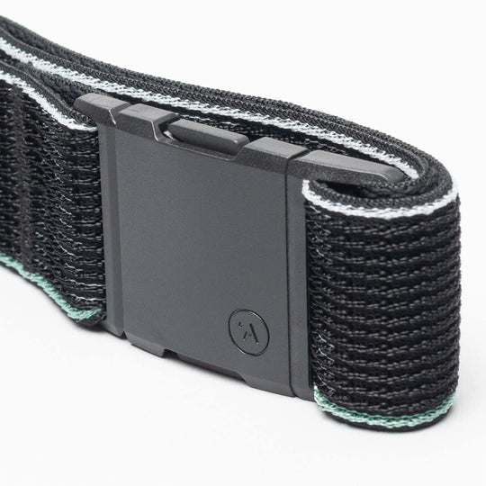 Close-up of the Arcade Belts Cubed, a black belt with a rectangular matte black buckle, textured pattern, thin light blue and white edges, and a small circular A logo.