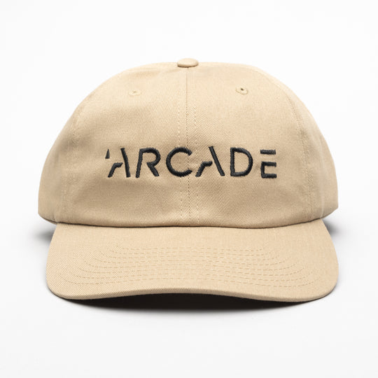 The Arcade Dad Hat by Arcade Belts features bold black ARCADE embroidery on beige and pairs perfectly with a low profile stretch web belt featuring a sleek plastic buckle.