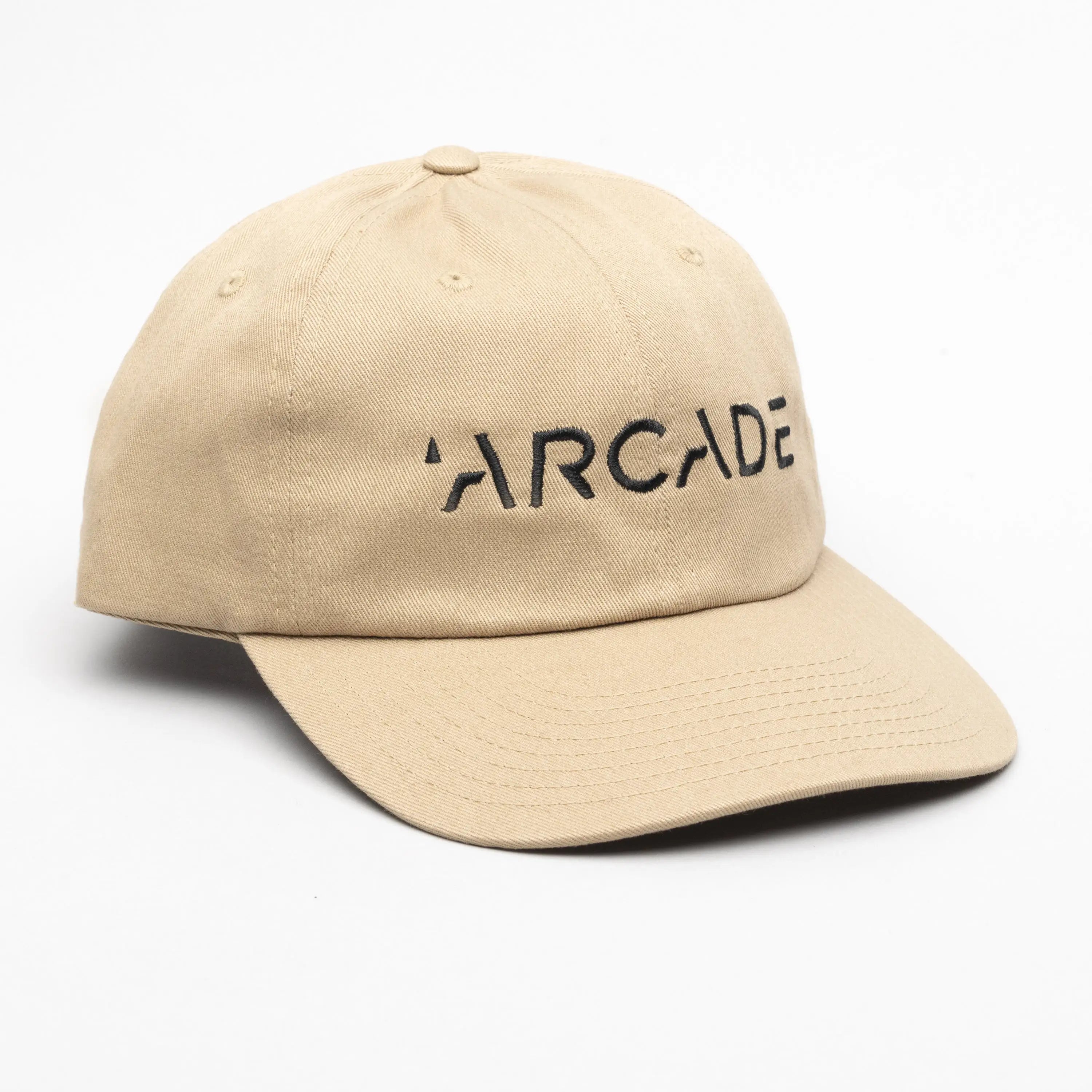 The Arcade Dad Hat by Arcade Belts is a beige baseball cap featuring “ARCADE” in black capital letters on the front, inspired by their iconic low profile belt style, shown on a white background.