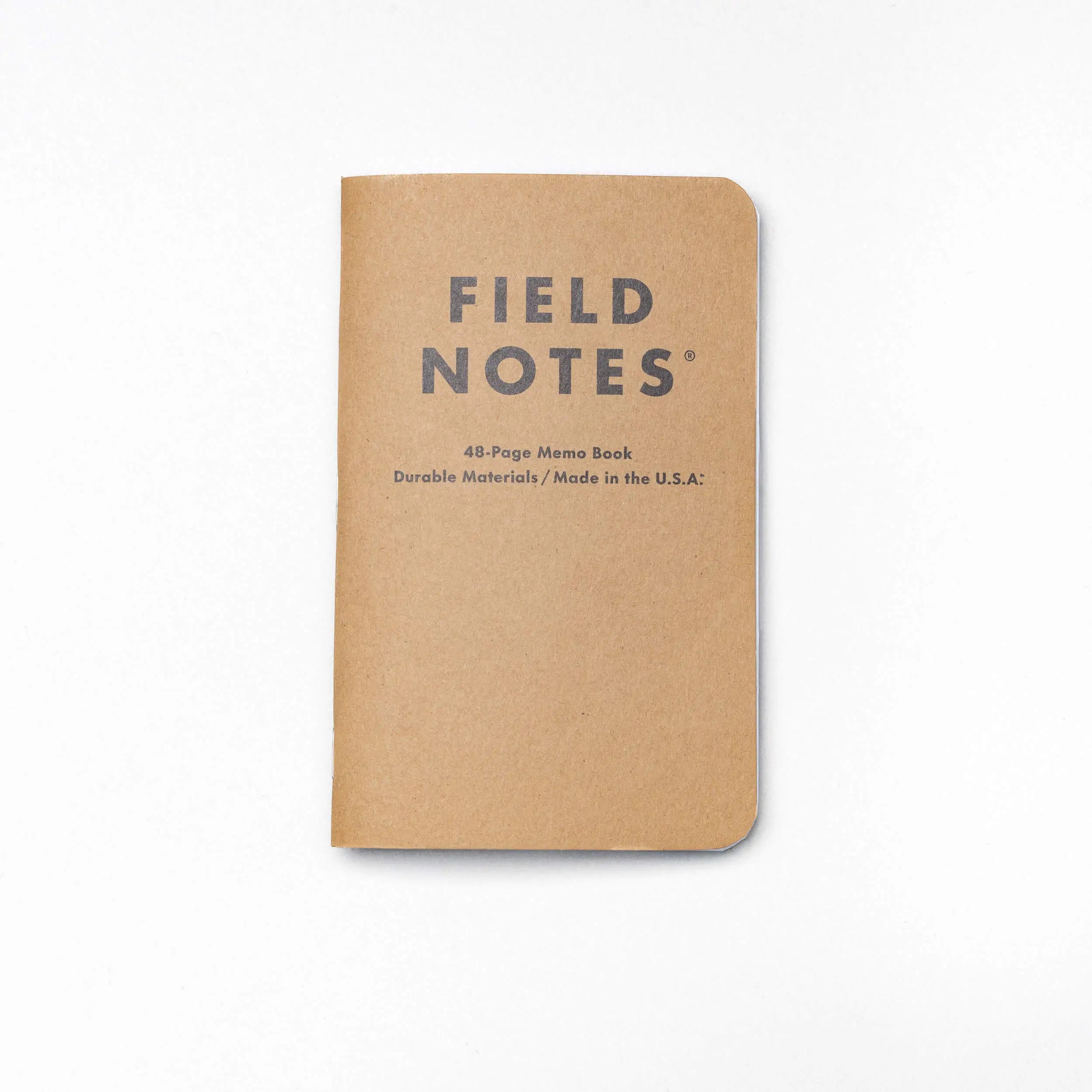 A tan, pocket-sized Field Notes memo book by Arcade Belts with rounded corners and FIELD NOTES on the cover—a durable and portable notebook set against a white background.