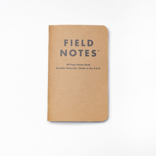 A tan, pocket-sized Field Notes memo book by Arcade Belts with rounded corners and FIELD NOTES on the cover—a durable and portable notebook set against a white background.