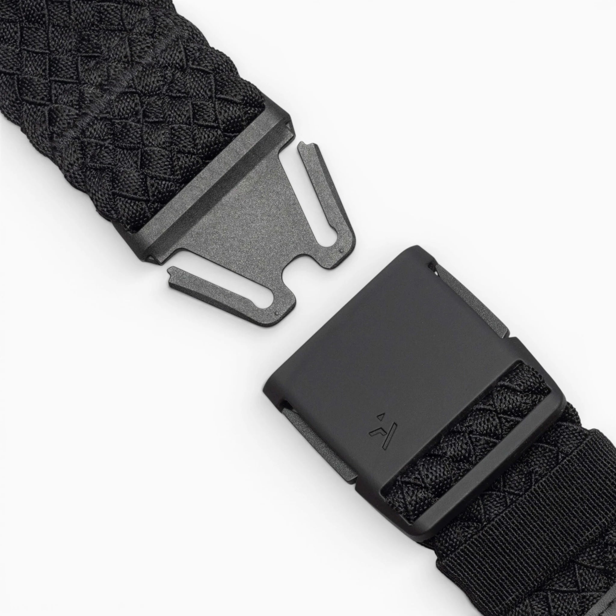 Close-up of the Arcade Belts Futureweave: a black woven belt with a matte black metal buckle, shown partially unclasped against a white background. It features a textured crisscross pattern for a comfortable fit.