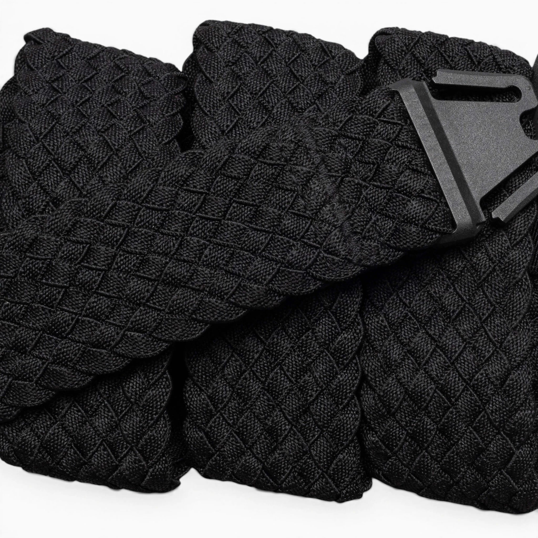 A close-up of the Arcade Belts Futureweave: a lightweight black belt featuring textured woven webbing and a matte black buckle, displayed neatly on a light background.
