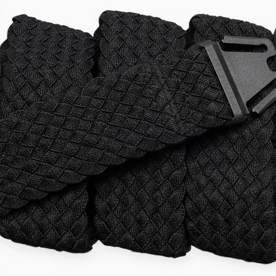 A close-up of the Arcade Belts Futureweave: a lightweight black belt featuring textured woven webbing and a matte black buckle, displayed neatly on a light background.