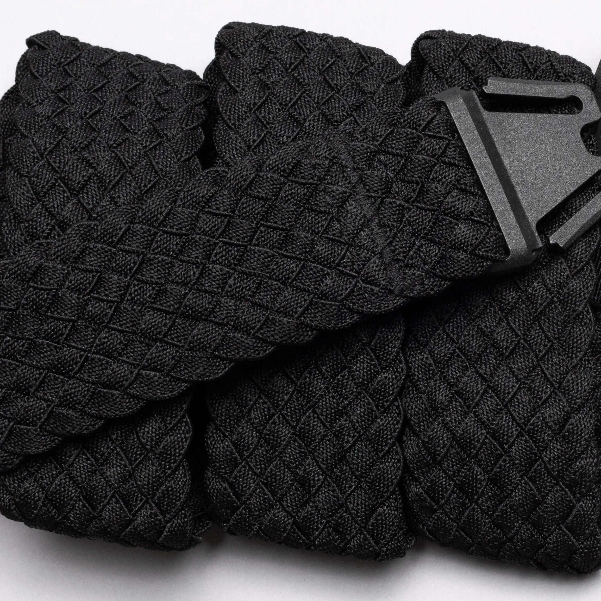 A close-up of the Arcade Belts Futureweave: a lightweight black belt featuring textured woven webbing and a matte black buckle, displayed neatly on a light background.