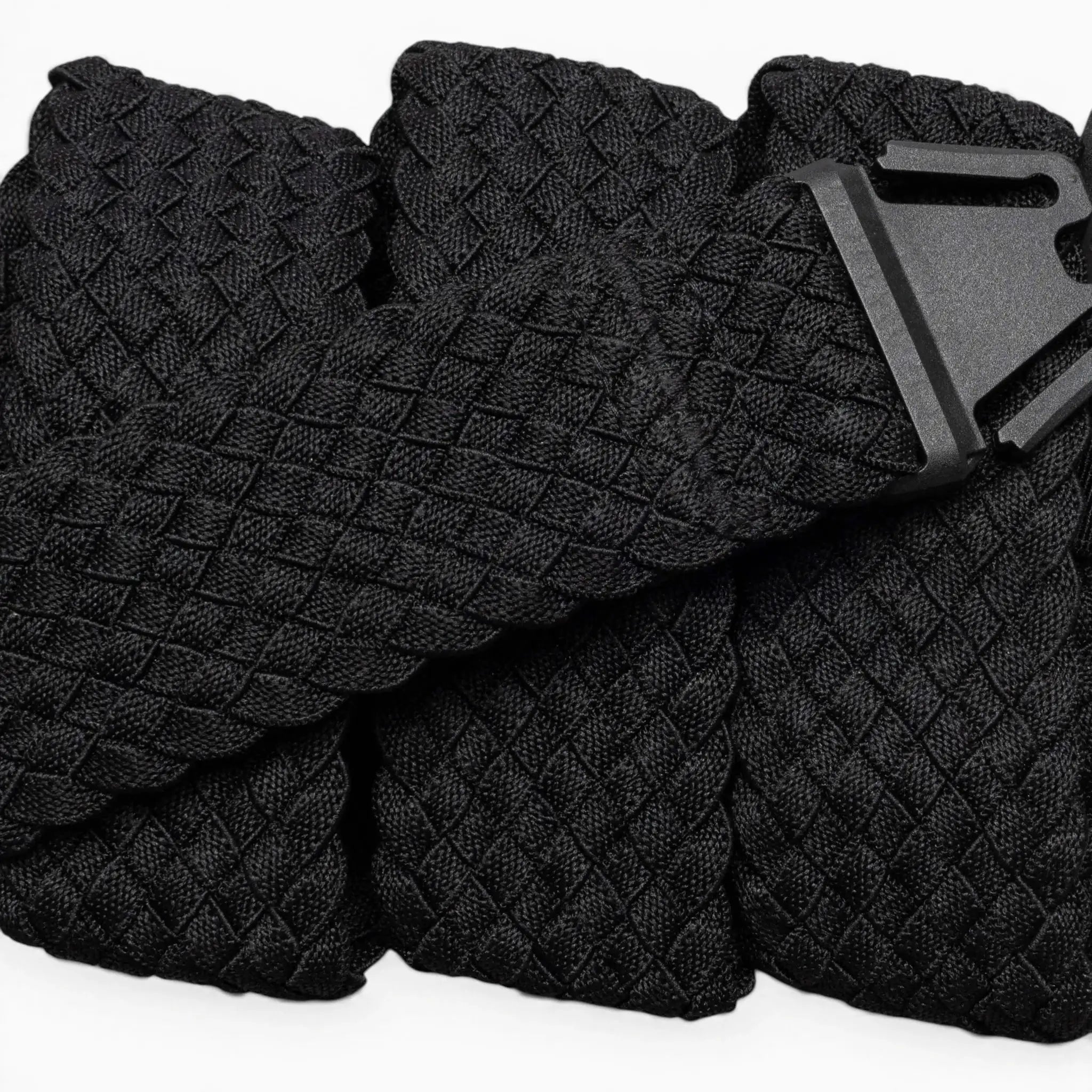 A close-up of the Arcade Belts Futureweave: a lightweight black belt featuring textured woven webbing and a matte black buckle, displayed neatly on a light background.
