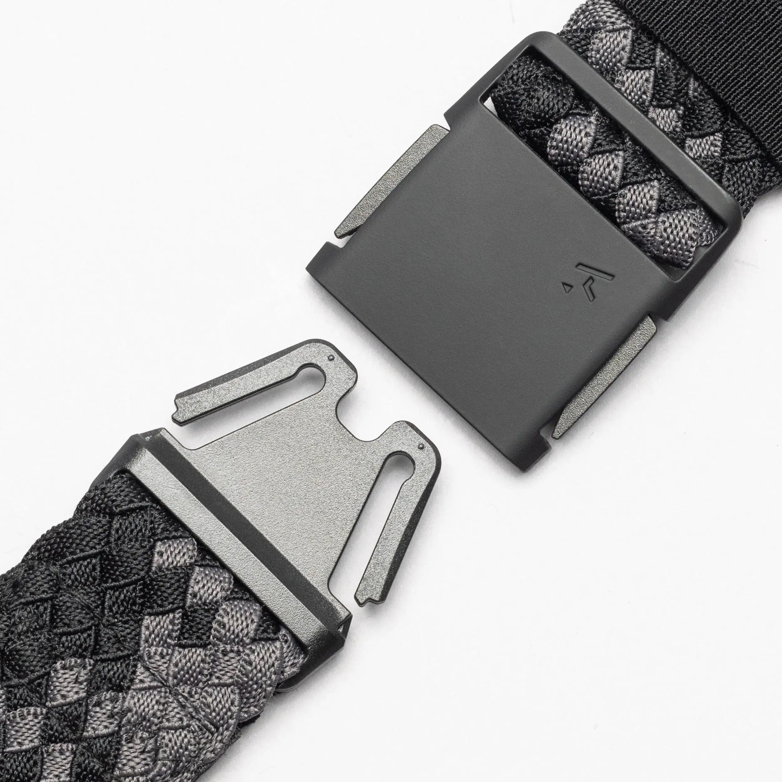 Close-up of the Arcade Belts Futureweave, a black and gray woven webbing belt with a rectangular metal buckle, shown with its two clasped ends separated on a white background.