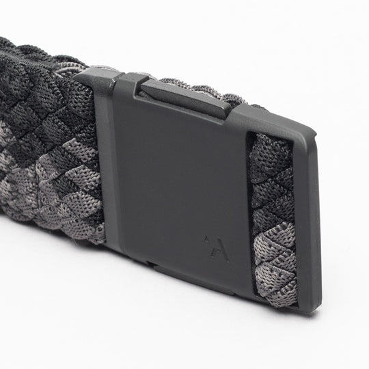 A close-up of the Arcade Belts Futureweave, a black and gray woven webbing paracord belt featuring a matte black rectangular buckle, set against a white background.
