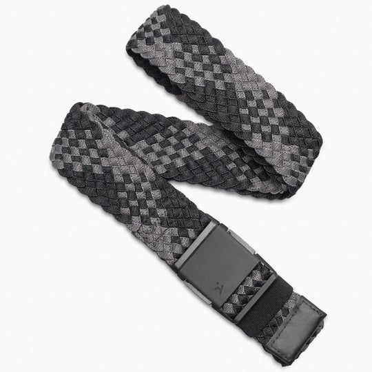 The Arcade Belts Futureweave Kit is a woven fabric belt with a black and gray checkered pattern, crafted using Futureweave technology for comfort. It features a rectangular black buckle and a matching checkered loop near the end.