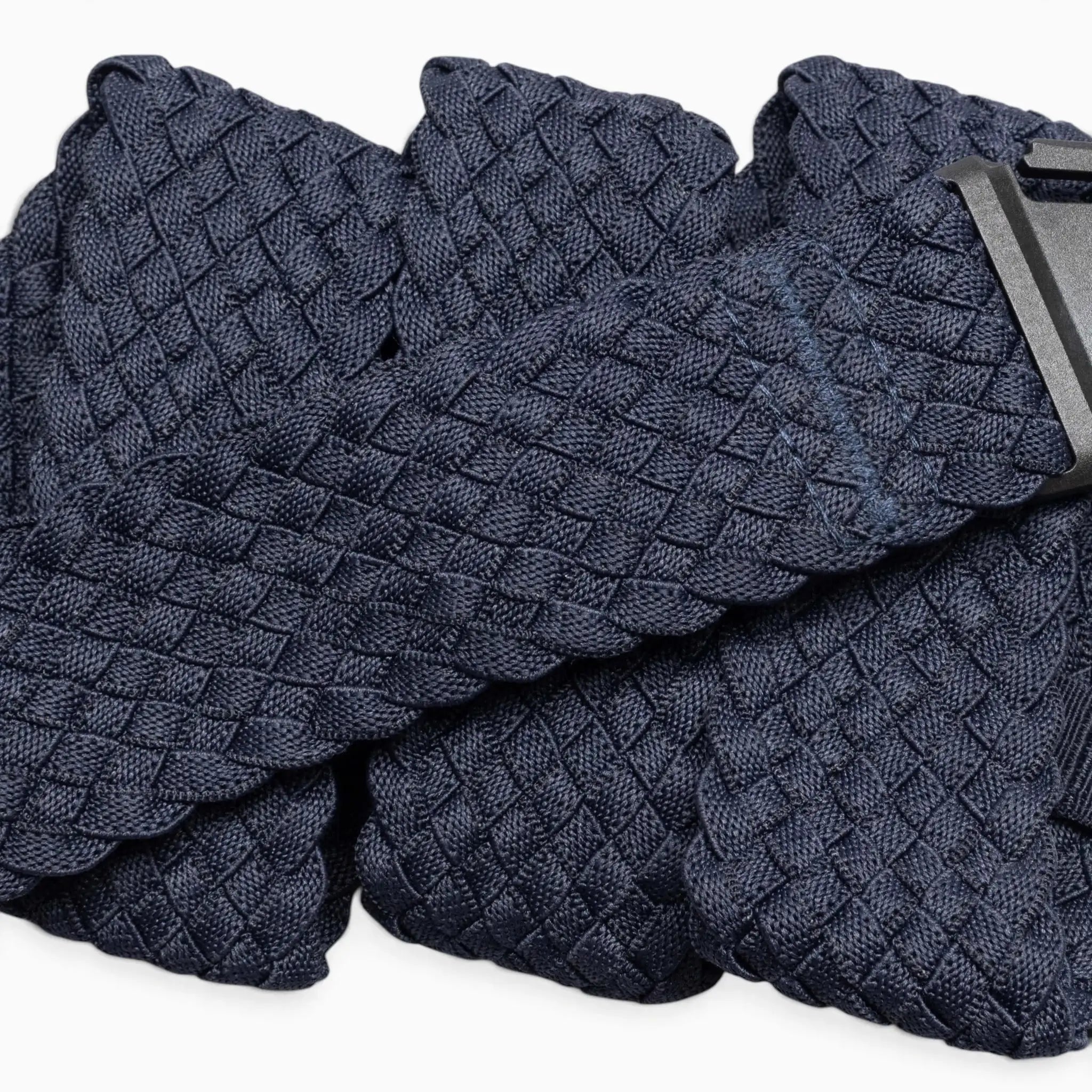 A close-up of the Arcade Belts Futureweave, a navy blue braided belt with a woven webbing texture and a black rectangular buckle, displayed against a white background. This lightweight belt combines style and comfort.