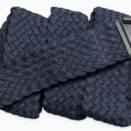 A close-up of the Arcade Belts Futureweave, a navy blue braided belt with a woven webbing texture and a black rectangular buckle, displayed against a white background. This lightweight belt combines style and comfort.