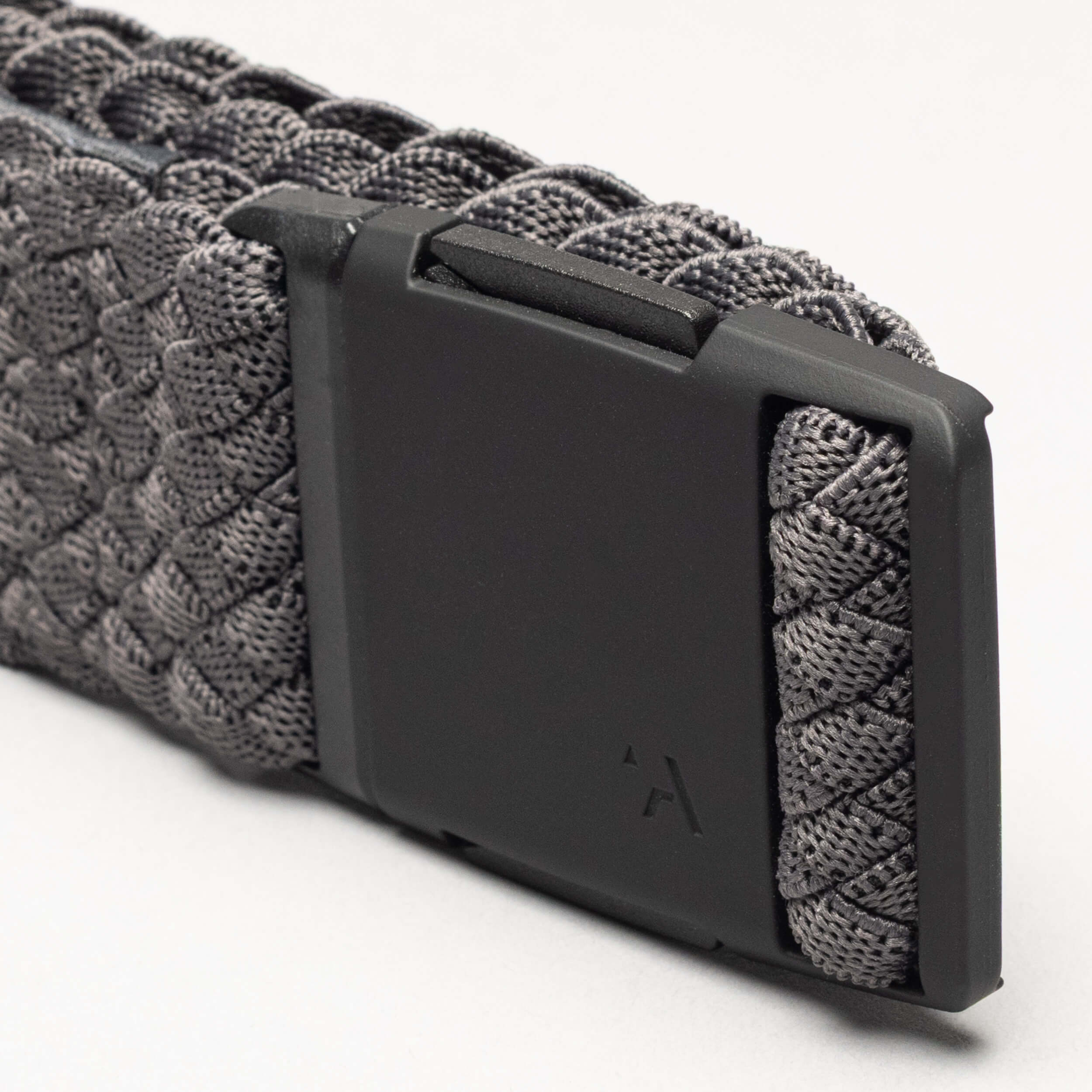 Close-up of the Arcade Belts Futureweave: a gray woven webbing belt with a matte black rectangular buckle, subtly engraved with the brand’s logo.