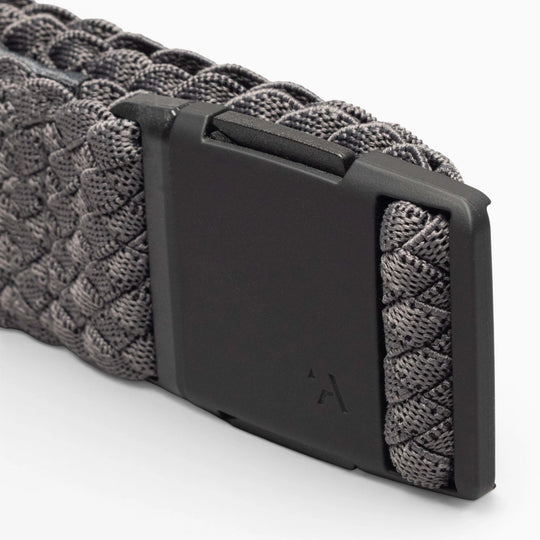 Close-up of the Arcade Belts Futureweave: a gray woven webbing belt with a matte black rectangular buckle, subtly engraved with the brand’s logo.