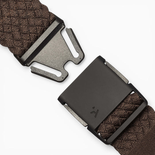 A close-up of the Futureweave belt by Arcade Belts, featuring brown woven webbing fabric and a black metal quick-release buckle, shown partially unclasped on a white background.