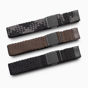 The Arcade Belts Futureweave Kit showcases three woven fabric belts in gray, brown, and black, each neatly rolled in a row on a white background. Every belt is finished with a rectangular, matte black buckle featuring a minimalist design that accentuates its classic style.