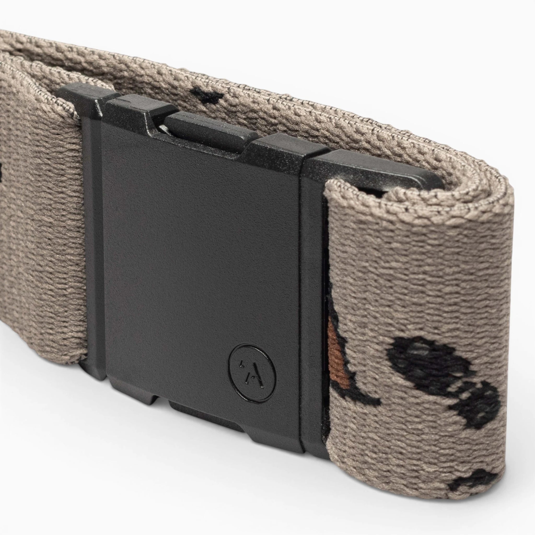 A close-up of the Arcade Belts Get Outside tan hiking belt, featuring a black rectangular buckle and a subtle pattern of small black and brown shapes. Ideal for outdoor adventures, shown against a plain light background.