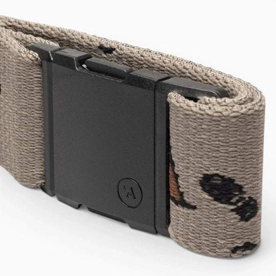 A close-up of the Arcade Belts Get Outside tan hiking belt, featuring a black rectangular buckle and a subtle pattern of small black and brown shapes. Ideal for outdoor adventures, shown against a plain light background.