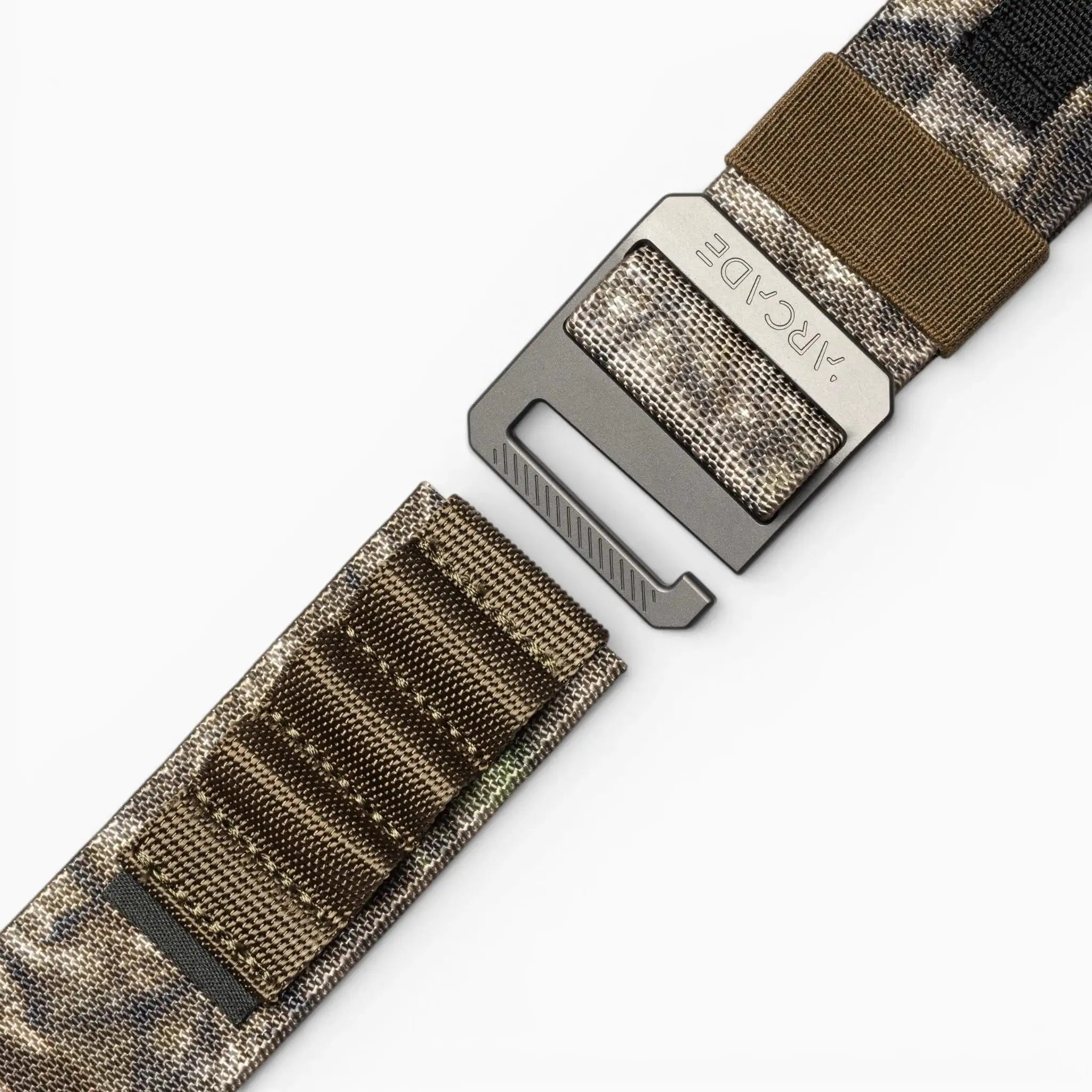 A close-up of the Hardware Alu belt by Arcade Belts, featuring a camouflage stretch webbing and a metal buckle, partially unfastened, displayed against a plain white background.