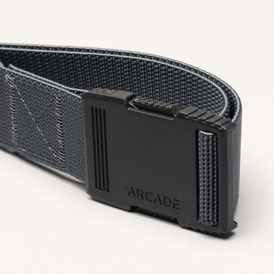 A close-up of the Arcade Belts Hardware: a dark gray woven belt with a matte black rectangular buckle engraved with Arcade, highlighted against a light background for superior strength.