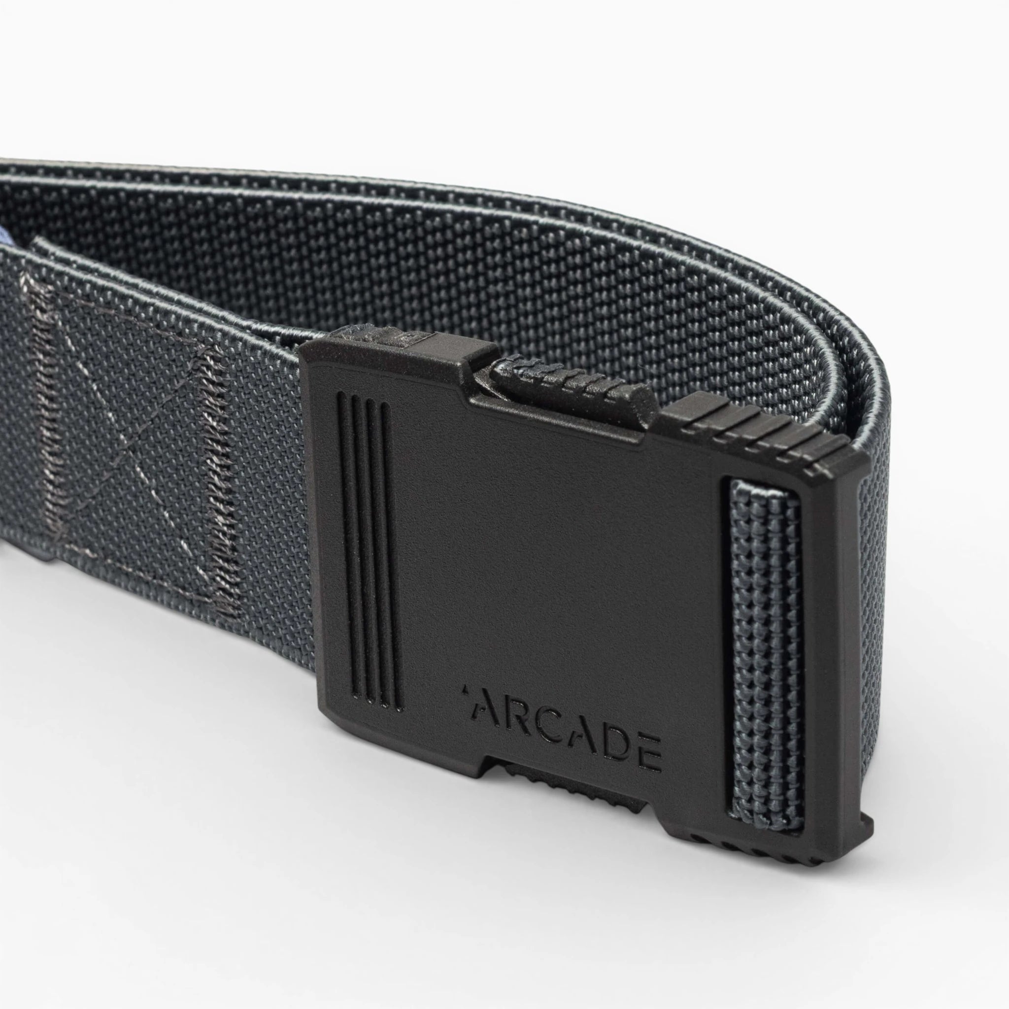 A close-up of the Arcade Belts Hardware: a dark gray woven belt with a matte black rectangular buckle engraved with Arcade, highlighted against a light background for superior strength.