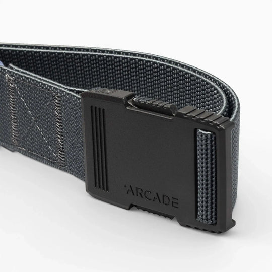 A close-up of the Arcade Belts Hardware: a dark gray woven belt with a matte black rectangular buckle engraved with Arcade, highlighted against a light background for superior strength.