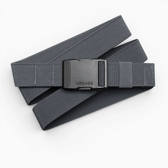 A gray woven Arcade Belts Hardware belt with superior strength and a black ARCADE-labeled plastic buckle is coiled loosely on a white background.