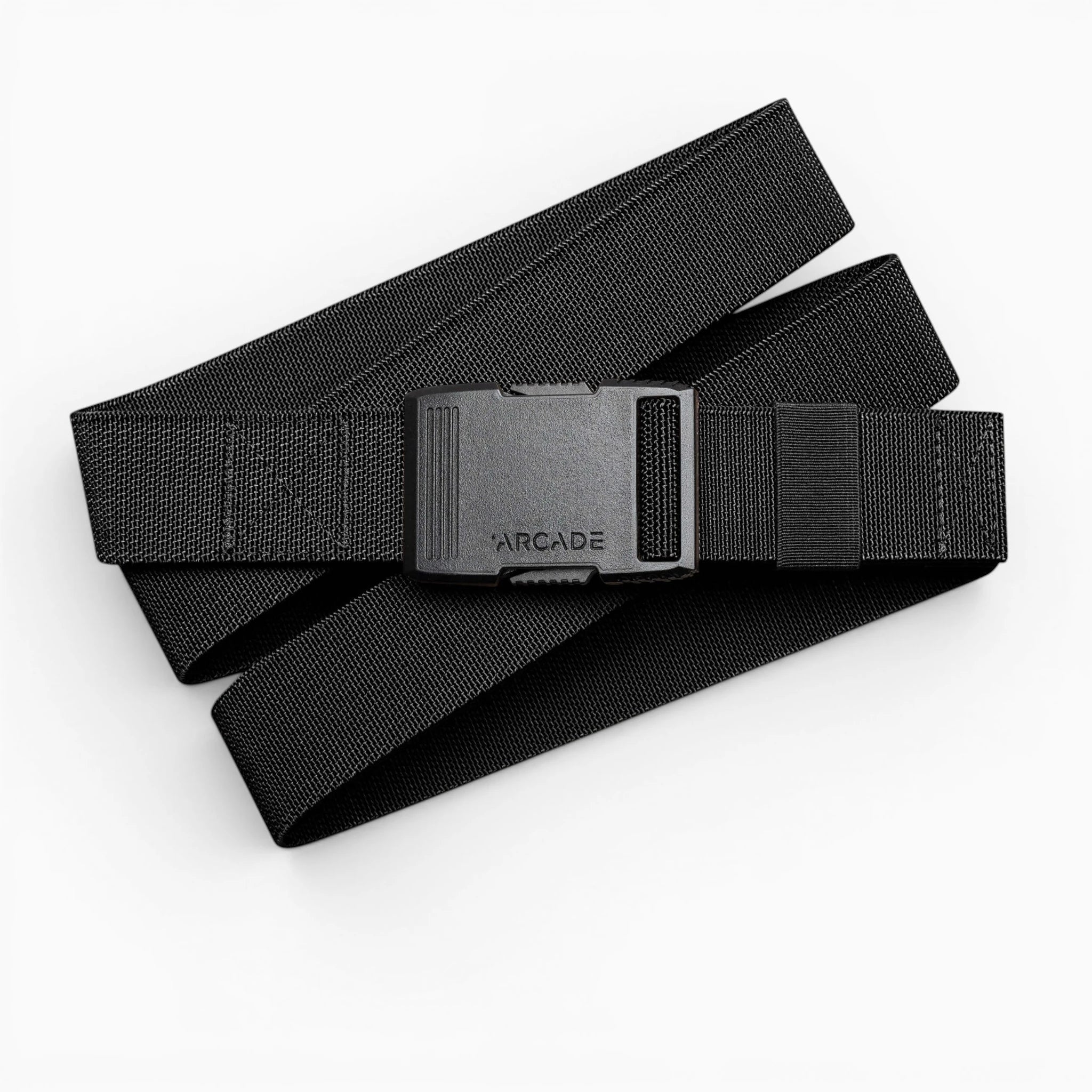 The Arcade Belts Hardware is a black elastic stretch belt with a low profile buckle engraved with ARCADE, neatly coiled on a white background.