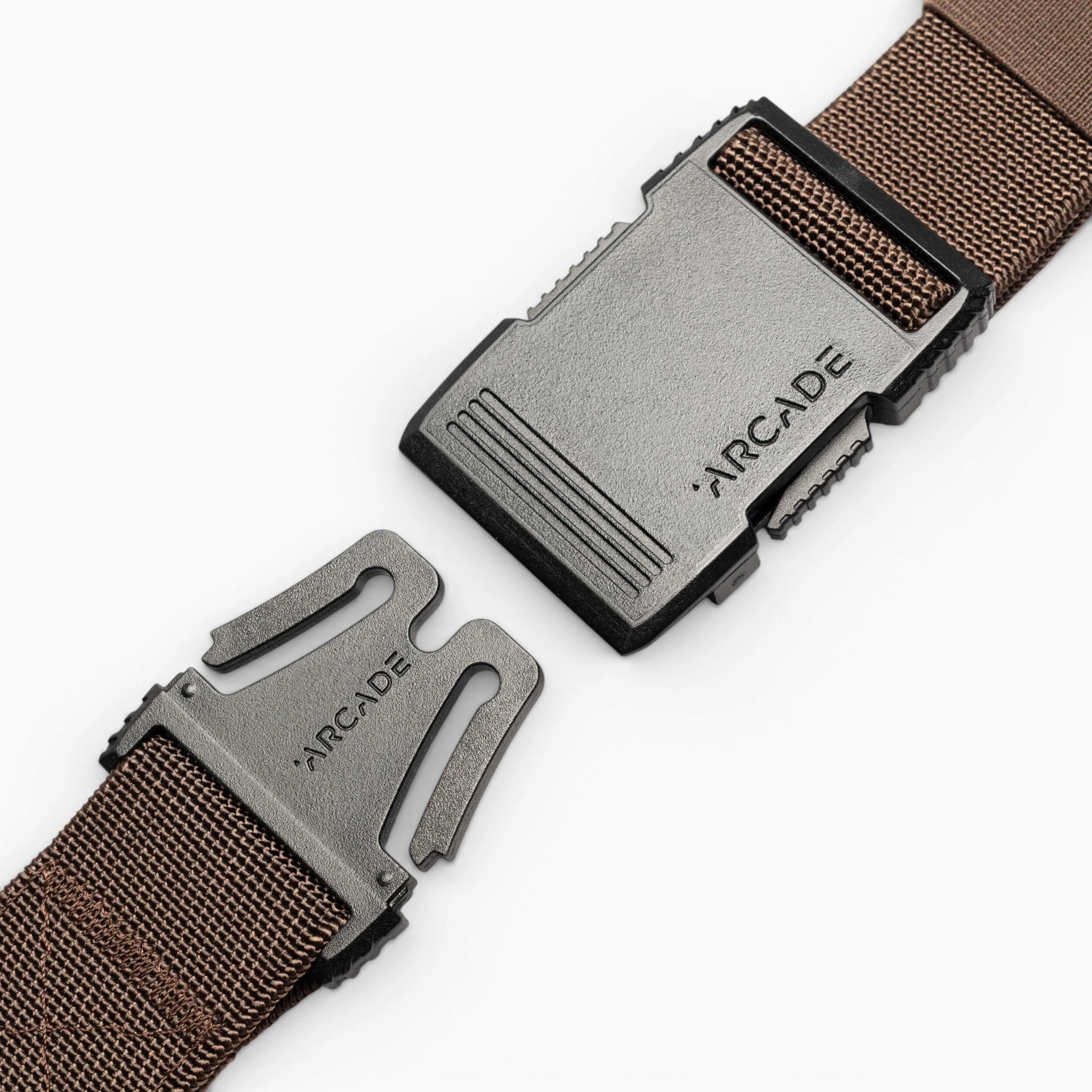 A close-up of the brown Arcade Belts Hardware belt with a black plastic buckle, both pieces engraved with ARCADE, displayed against a white background.