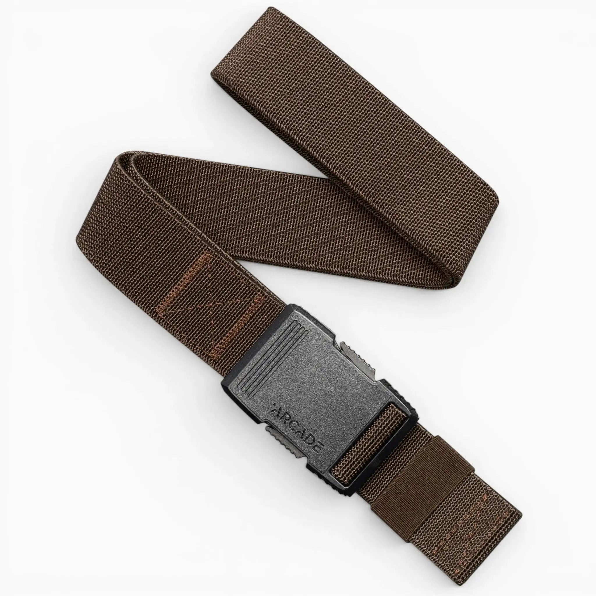 The Arcade Belts Hardware is a brown woven stretch webbing belt with a black rectangular plastic buckle branded with ARCADE, partially coiled and lying flat on a white background.